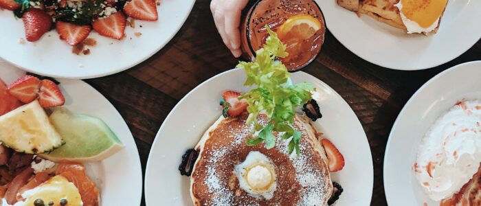 Pancakes, eggs Benedict and salad Pancakes, eggs Benedict, home fries and strawberry spinach salad on a table at Crepes on Cole in Cole Valley